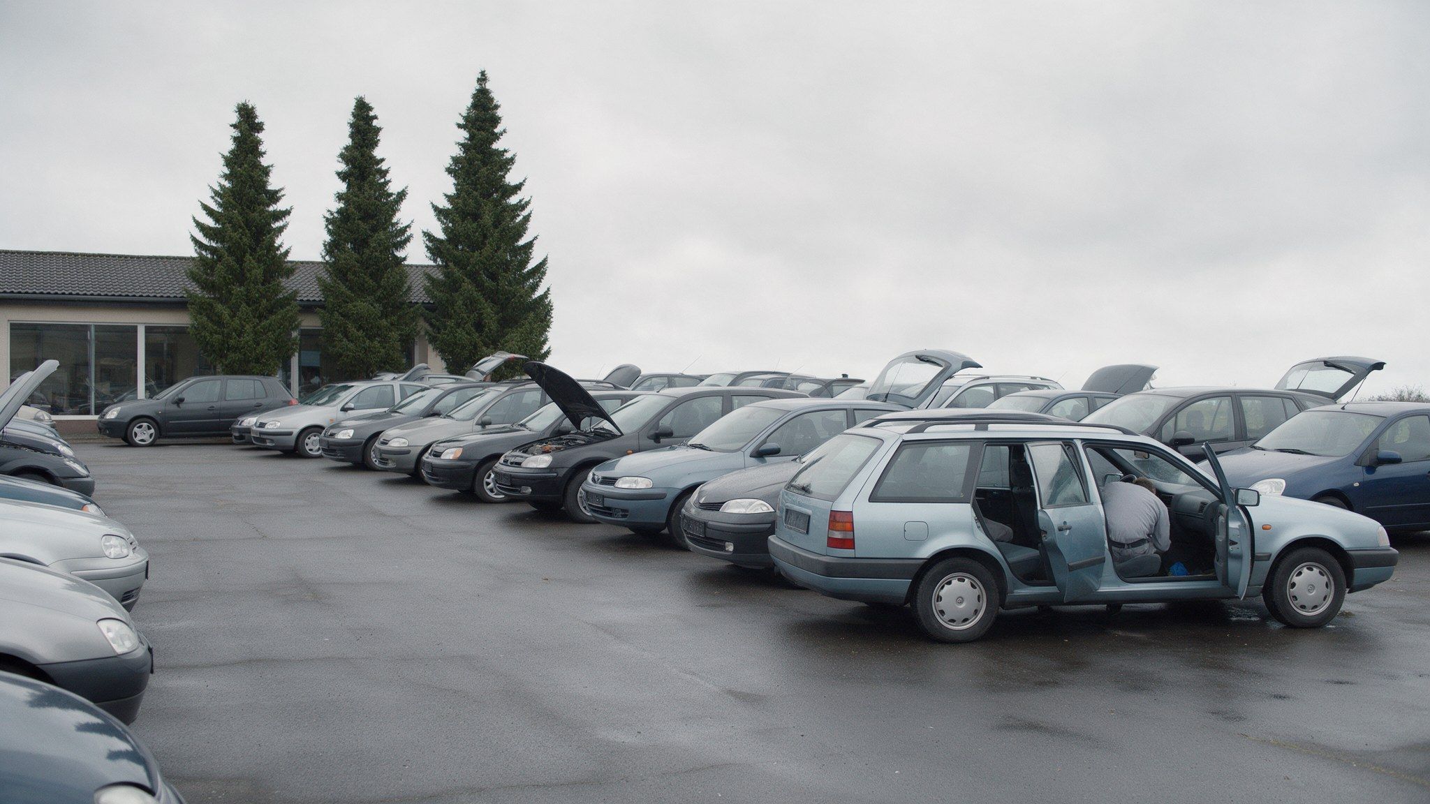 Aufbereiter bereitet einen Gebrauchtwagen auf dem Hof eines Autohauses vor